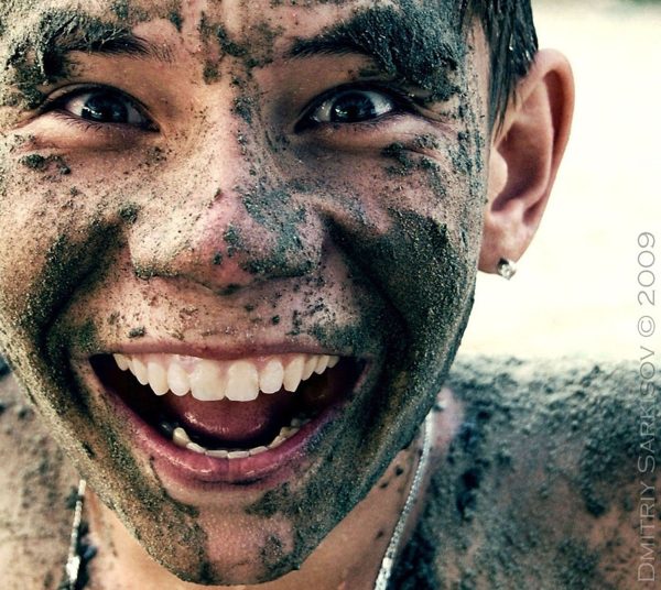 kid smiling and happy playing in mud